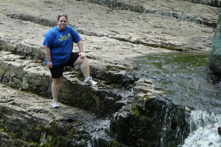 Melissa (Female) with blue shirt and black shorts on climbing the Waterfalls of Ringing Rocks Park.